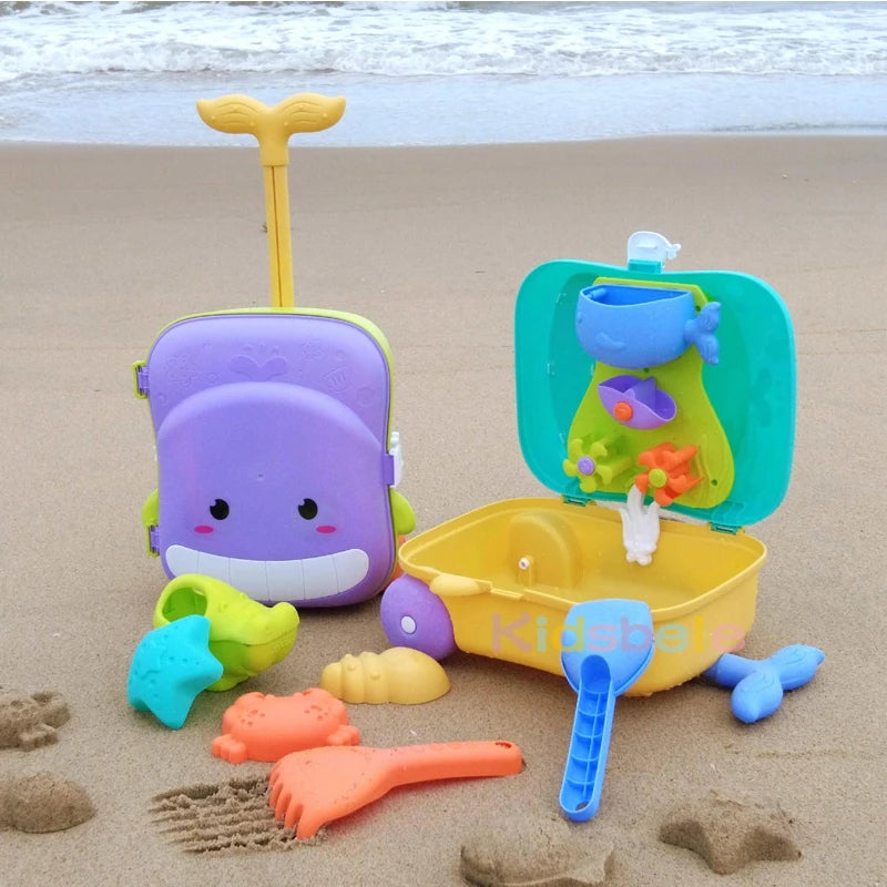 Purple whale SandSplash trolley case on the beach with an open case, rake and molds